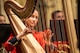 A harp player plays their instrument