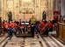 A conductor stands in front of the band waiting to perform