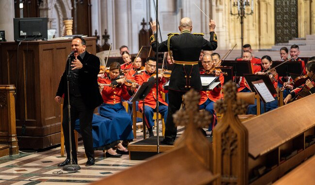 A band plays their instruments while opera singer is singing