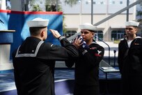 Sailors salute the ensign during a retirement ceremony in  Pensacola, Fla.