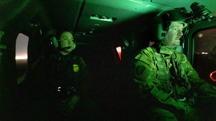 A U.S. Border Patrol agent alongside U.S. Soldiers with Bravo Company, 3rd Battalion, 140th Aviation Regiment assigned to Task Force Sentinel, conduct aerial reconnaissance