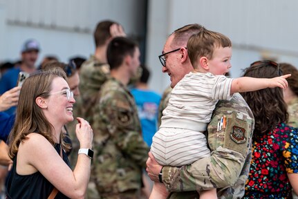 man holds child while talking to woman