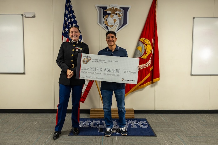 U.S. Marine Corps Capt. Brianna K. LeCompte, the executive officer of Recruiting Station Austin, poses for a picture with Moises Aguirre after the presentation of the Naval Reserve Officer Training Corps scholarship at Hendrickson High School in Pflugerville, Texas, Jan. 15, 2025. Students selected for this prestigious scholarship program must uphold strict physical standards and successfully complete additional military courses while maintaining normal college coursework responsibilities. (U.S. Marine Corps photo by Cpl. Jose D. Cruz)