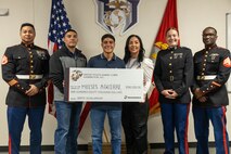 U.S. Marines with Recruiting Station Austin, pose for a after a presentation of the Naval Reserve Officer Training Corps scholarship at Hendrickson High School in Pflugerville, Texas, Jan. 15, 2025. Students selected for this prestigious scholarship program must uphold strict physical standards and successfully complete additional military courses while maintaining normal college coursework responsibilities. (U.S. Marine Corps photo by Cpl. Jose D. Cruz)