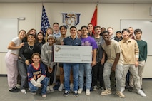 Moises Aguirre and students from Hendrickson High School, pose for a picture during the presentation of the Naval Reserve Officer Training Corps scholarship at Hendrickson High School in Pflugerville, Texas, Jan. 15, 2025. Students selected for this prestigious scholarship program must uphold strict physical standards and successfully complete additional military courses while maintaining normal college coursework responsibilities. (U.S. Marine Corps photo by Cpl. Jose D. Cruz)