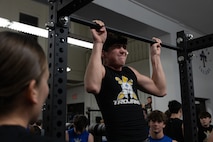 U.S. Marine Corps Capt. Brianna K. LeCompte, the executive officer of Recruiting Station Austin, supervises as a student of Anderson High School conducts a pull up during the Initial Strength Assessment at Anderson High School in Austin, Texas, Jan. 15, 2025. During the visit, Marines hosted an Initial Strength Assessment with Anderson High School students. (U.S. Marine Corps photo by Cpl. Jose D. Cruz)