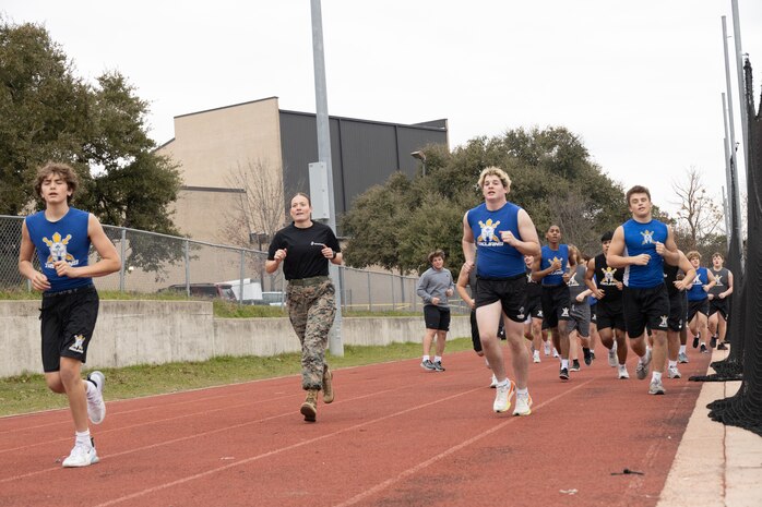 U.S. Marine Corps Capt. Brianna K. LeCompte, the executive officer of Recruiting Station Austin and students with Anderson High School, conduct an one and a half mile run during the Initial Strength Assessment at Anderson High School in Austin, Texas, Jan. 15, 2025. During the visit, Marines hosted an Initial Strength Assessment with Anderson High School students. (U.S. Marine Corps photo by Cpl. Jose D. Cruz)