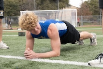 An Anderson High School student, conducts a plank during a school visit at Anderson High School in Austin, Texas, Jan. 15, 2025. During this visit, the Marines conducted an Initial Strength Assessment with Anderson High School students. (U.S. Marine Corps photo by Cpl. Jose)