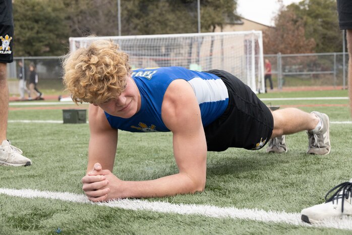 An Anderson High School student, conducts a plank during a school visit at Anderson High School in Austin, Texas, Jan. 15, 2025. During this visit, the Marines conducted an Initial Strength Assessment with Anderson High School students. (U.S. Marine Corps photo by Cpl. Jose)