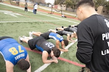 U.S. Marine Corps Sgt. Ryan N. Juarez, a recruiter with Recruiting Sub-Station Round Rock, Recruiting Station Austin, supervises as students of Anderson High School conduct planks during the Initial Strength Assessment at Anderson High School in Austin, Texas, Jan. 15, 2025. During the visit, Marines hosted an Initial Strength Assessment with Anderson High School students. (U.S. Marine Corps photo by Cpl. Jose D. Cruz)