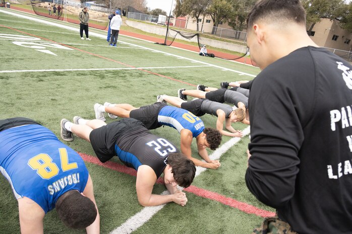 U.S. Marine Corps Sgt. Ryan N. Juarez, a recruiter with Recruiting Sub-Station Round Rock, Recruiting Station Austin, supervises as students of Anderson High School conduct planks during the Initial Strength Assessment at Anderson High School in Austin, Texas, Jan. 15, 2025. During the visit, Marines hosted an Initial Strength Assessment with Anderson High School students. (U.S. Marine Corps photo by Cpl. Jose D. Cruz)