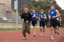U.S. Marine Corps Sgt. Ryan N. Juarez, a recruiter with Recruiting Sub-Station Round Rock, Recruiting Station Austin and students from Anderson High School, conducts an one and a half mile run during the Initial Strength Assessment at Anderson High School in Austin, Texas, Jan. 15, 2025. During the visit, Marines hosted an Initial Strength Assessment with Anderson High School students. (U.S. Marine Corps photo by Cpl. Jose D. Cruz)