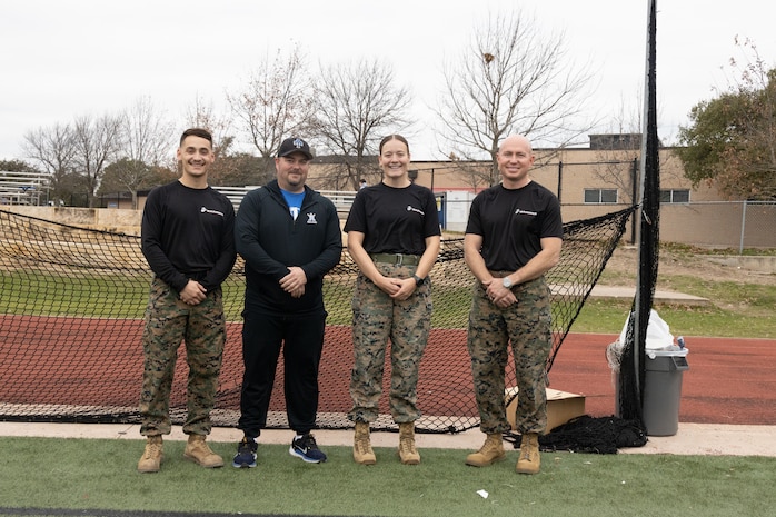 U.S. Marines with Recruiting Station Austin and the head coach of Anderson High School, pose for a picture after the Initial Strength Assessment at Anderson High School in Austin, Texas, Jan. 15, 2025. During the visit, Marines hosted an Initial Strength Test with Anderson High School students. (U.S. Marine Corps photo by Cpl. Jose D. Cruz)