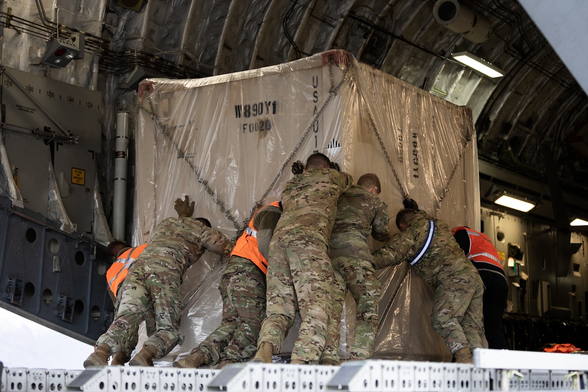 Airmen load cargo into an aircraft.