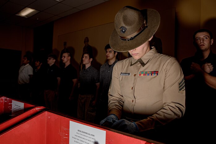 U.S. Marine Corps Drill Instructor Sgt. Natali Morenogardez with Receiving Company, Support Battalion, inspects recruits’ belongings during Hotel Company, 2nd Recruit Training Battalion, receiving event at Marine Corps Recruit Depot San Diego, California, Jan.13, 2025. During the receiving process, recruits are taken to the United States Organizations for accountability, checked for contraband, given haircuts, make a scripted phone call home, and issued gear required for training. (U.S. Marine Corps photo by Cpl. Sarah M. Grawcock)