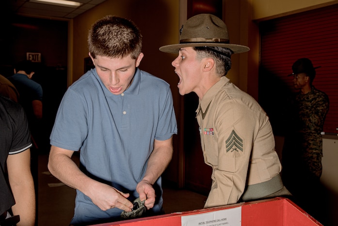 U.S. Marine Corps Drill Instructor Sgt. Natali Morenogardez with Receiving Company, Support Battalion, instructs a recruit during Hotel Company, 2nd Recruit Training Battalion, receiving event at Marine Corps Recruit Depot San Diego, California, Jan.13, 2025. During the receiving process, recruits are taken to the United States Organizations for accountability, checked for contraband, given haircuts, make a scripted phone call home, and issued gear required for training. (U.S. Marine Corps photo by Cpl. Sarah M. Grawcock)