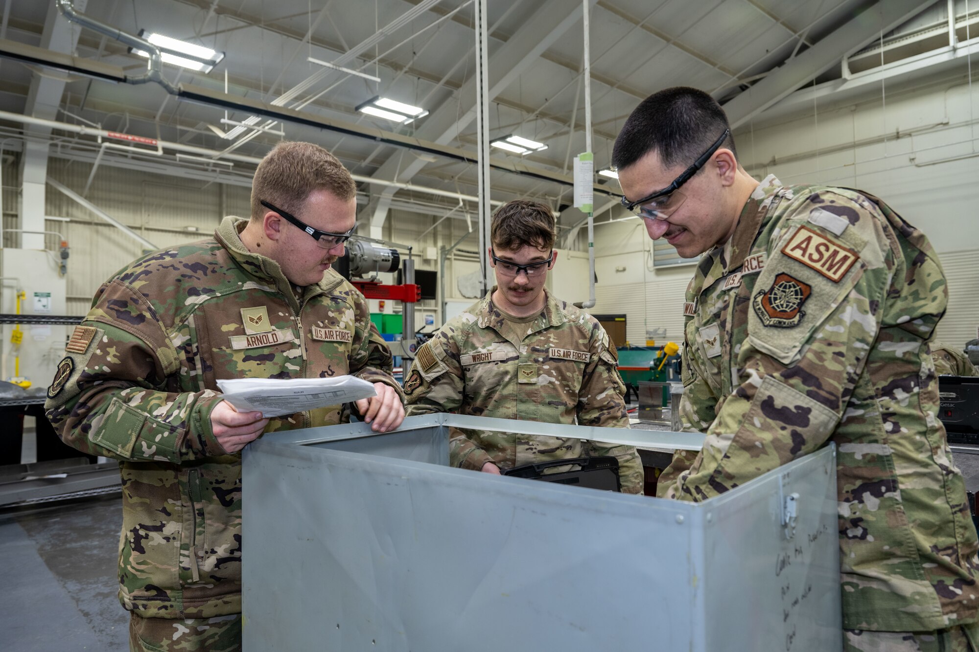 From left, Senior Airman Logan Arnold, 22nd Maintenance Squadron aircraft structural maintenance journeyman, Airman 1st Class Seth Wright, and Airman 1st Class Nicholas Wilkom, 22nd MXS aircraft structural maintenance apprentices, inspect a part to determine repair procedures Jan. 15, 2025, at McConnell Air Force Base, Kansas. MXS fabricates parts for the structural maintenance of the KC-135 Stratotanker and KC-46 Pegasus. (U.S. Air Force photo by Airman 1st Class Paula Arce)