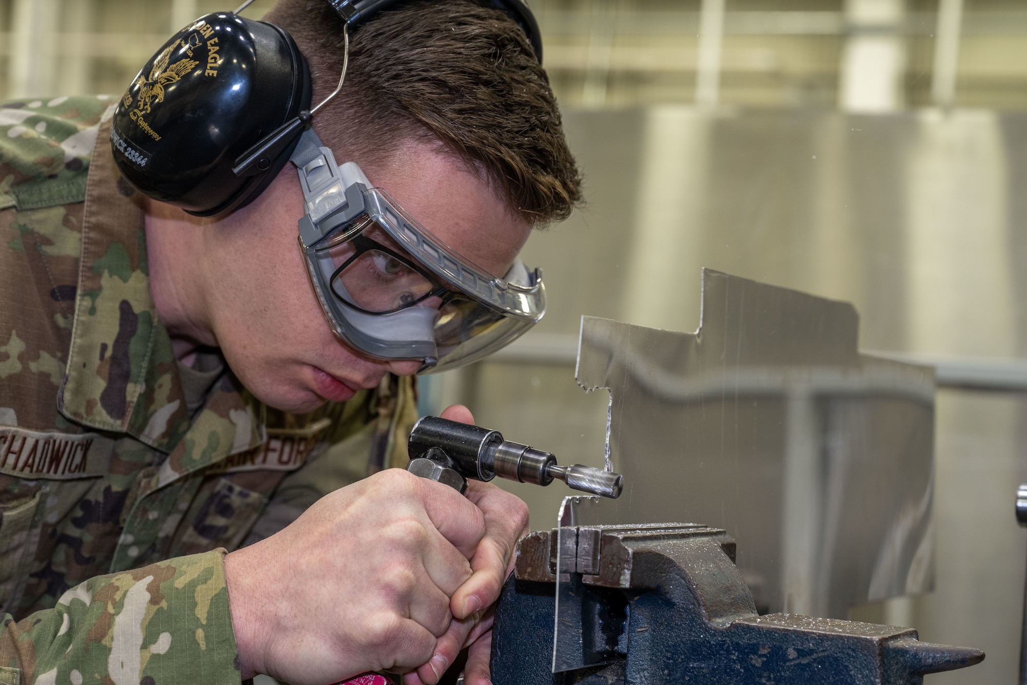 Senior Airman Caleb Chadwick, 22nd Maintenance Squadron aircraft structural maintenance journeyman, uses a pneumatic rotary barrel file to trim a repair aircraft part Jan. 15, 2025, at McConnell Air Force Base, Kansas. The 22nd MXS fabricates parts for the structural maintenance of the KC-135 Stratotanker and KC-46 Pegasus. (U.S. Air Force photos by Airman 1st Class Paula Arce)