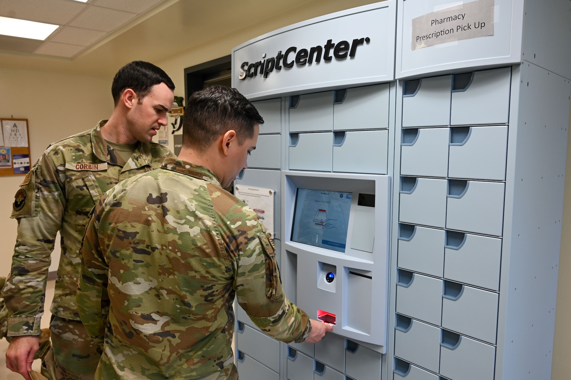 U.S. Air Force Maj. Timothy Corbin, therapeutics flight commander and Senior Airman Elijah Munoz, pharmacy technician, 36th Healthcare Operations Squadron, use the new ScriptCenter at the 36th Medical Group, Andersen Air Force Base, Guam, Jan. 22, 2025. The ScriptCenter is a safe and secure locker system for prescription refill pick-ups and is available to all Tricare beneficiaries. (U.S. Air Force photo by Airman 1st Class Natasha Ninete)