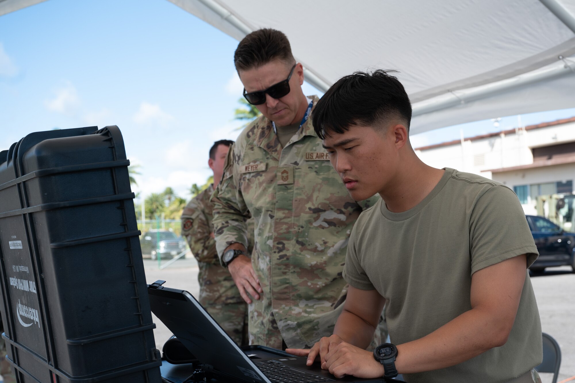 Two airmen are looking at a computer.