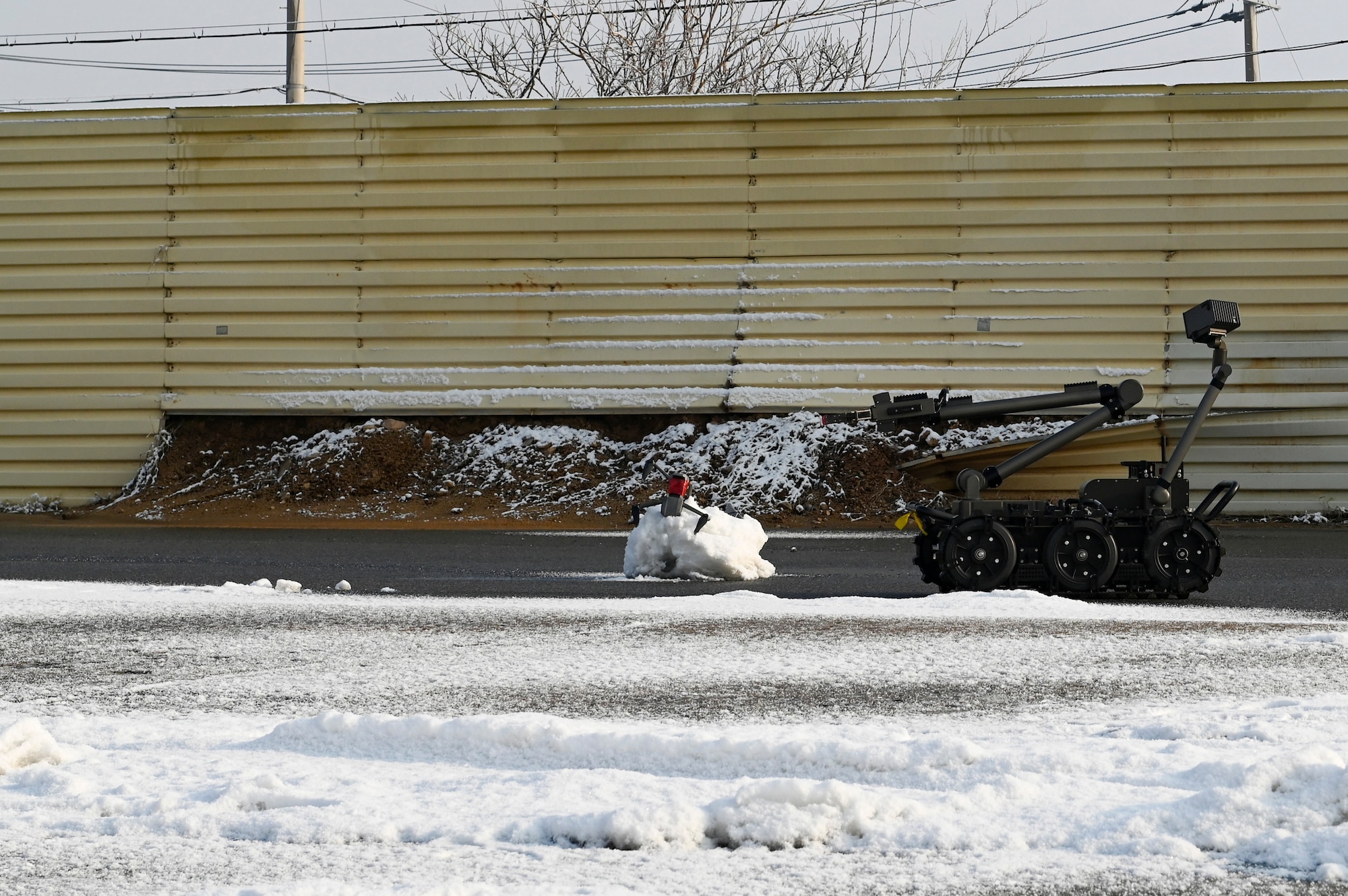 A man transportable robotic system controlled by the 8th Civil Engineer Squadron explosive ordnance disposal team is on scene at a simulated downed drone and ordnance during Beverly Pack 25-1.