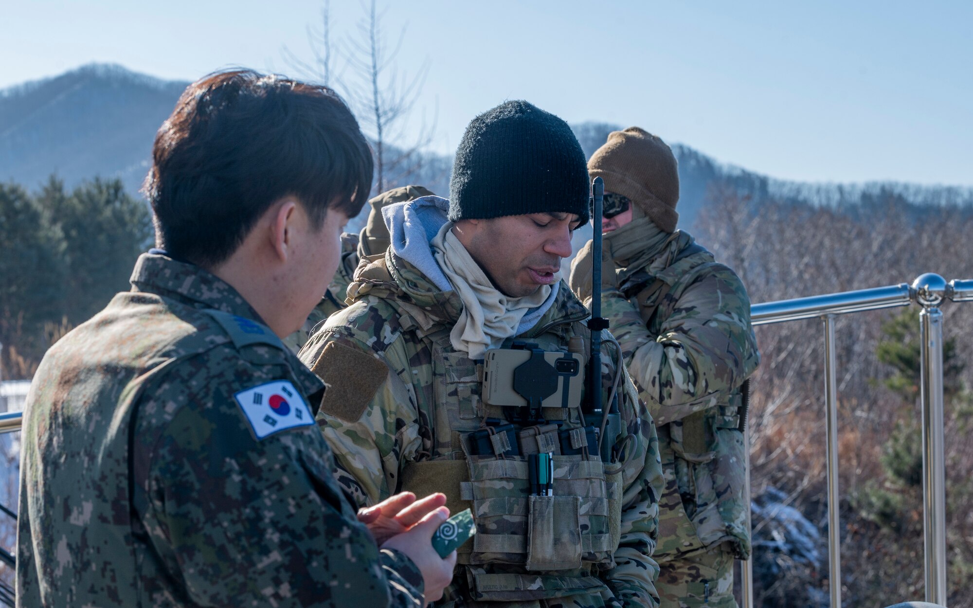 U.S. Air Force Staff Sgt. Walter Frank, 607th Air Support Operations Group tactical air control party specialist, speaks to a Republic of Korea Air Force member during bilateral training at Pilsung Range in Gangwon Province, Republic of Korea, Jan. 15, 2025. TACPs direct airstrikes and close air support from the ground using various methods of communication with the pilots in the air. This bilateral training ensures the strength needed to protect the Korean peninsula. (U.S. Air Force photo by Staff Sgt. Ashley N. Mikaio)