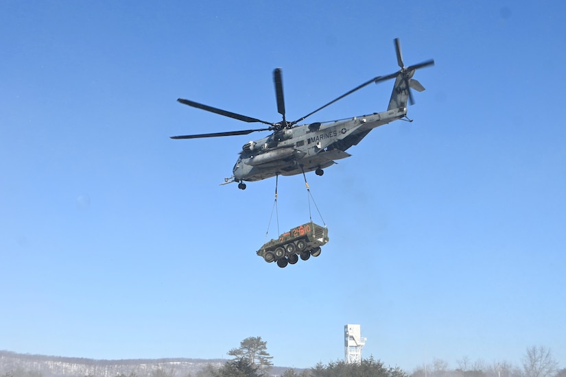 A Marine CH-53 Super Stallion helicopter from Marine Heavy Helicopter Squadron 772 out of Joint Base Maguire-Dix-Lakehurst, New Jersey, air-lifts a decommissioned Army Stryker vehicle to Fort Indiantown Gap’s impact area Jan. 22, 2025. A team of Air Force sling-load specialists from the 621st Contingency Response Group sling-loaded the Stryker to the helicopter. (Pennsylvania National Guard photo by Brad Rhen)