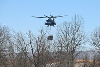 A Marine CH-53 Super Stallion helicopter from Marine Heavy Helicopter Squadron 772 out of Joint Base Maguire-Dix-Lakehurst, New Jersey, air-lifts a decommissioned Army Stryker vehicle to Fort Indiantown Gap’s impact area Jan. 22, 2025. A team of Air Force sling-load specialists from the 621st Contingency Response Group sling-loaded the Stryker to the helicopter. (Pennsylvania National Guard photo by Brad Rhen)