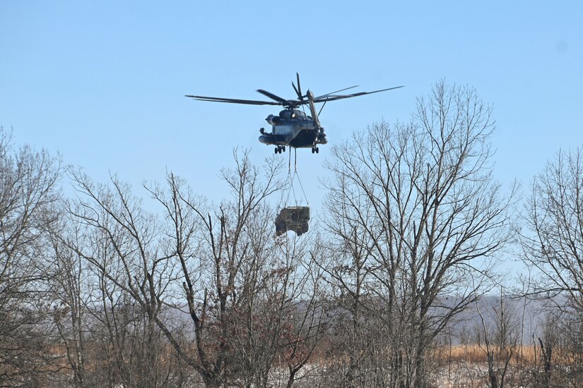 A Marine CH-53 Super Stallion helicopter from Marine Heavy Helicopter Squadron 772 out of Joint Base Maguire-Dix-Lakehurst, New Jersey, air-lifts a decommissioned Army Stryker vehicle to Fort Indiantown Gap’s impact area Jan. 22, 2025. A team of Air Force sling-load specialists from the 621st Contingency Response Group sling-loaded the Stryker to the helicopter. (Pennsylvania National Guard photo by Brad Rhen)