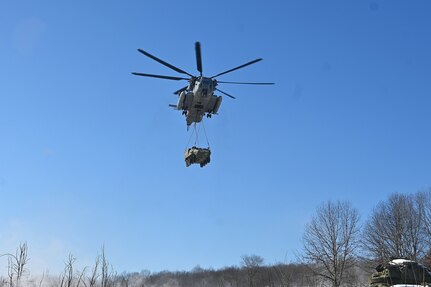 A Marine CH-53 Super Stallion helicopter from Marine Heavy Helicopter Squadron 772 out of Joint Base Maguire-Dix-Lakehurst, New Jersey, air-lifts a decommissioned Army Stryker vehicle to Fort Indiantown Gap’s impact area Jan. 22, 2025. A team of Air Force sling-load specialists from the 621st Contingency Response Group sling-loaded the Stryker to the helicopter. (Pennsylvania National Guard photo by Brad Rhen)