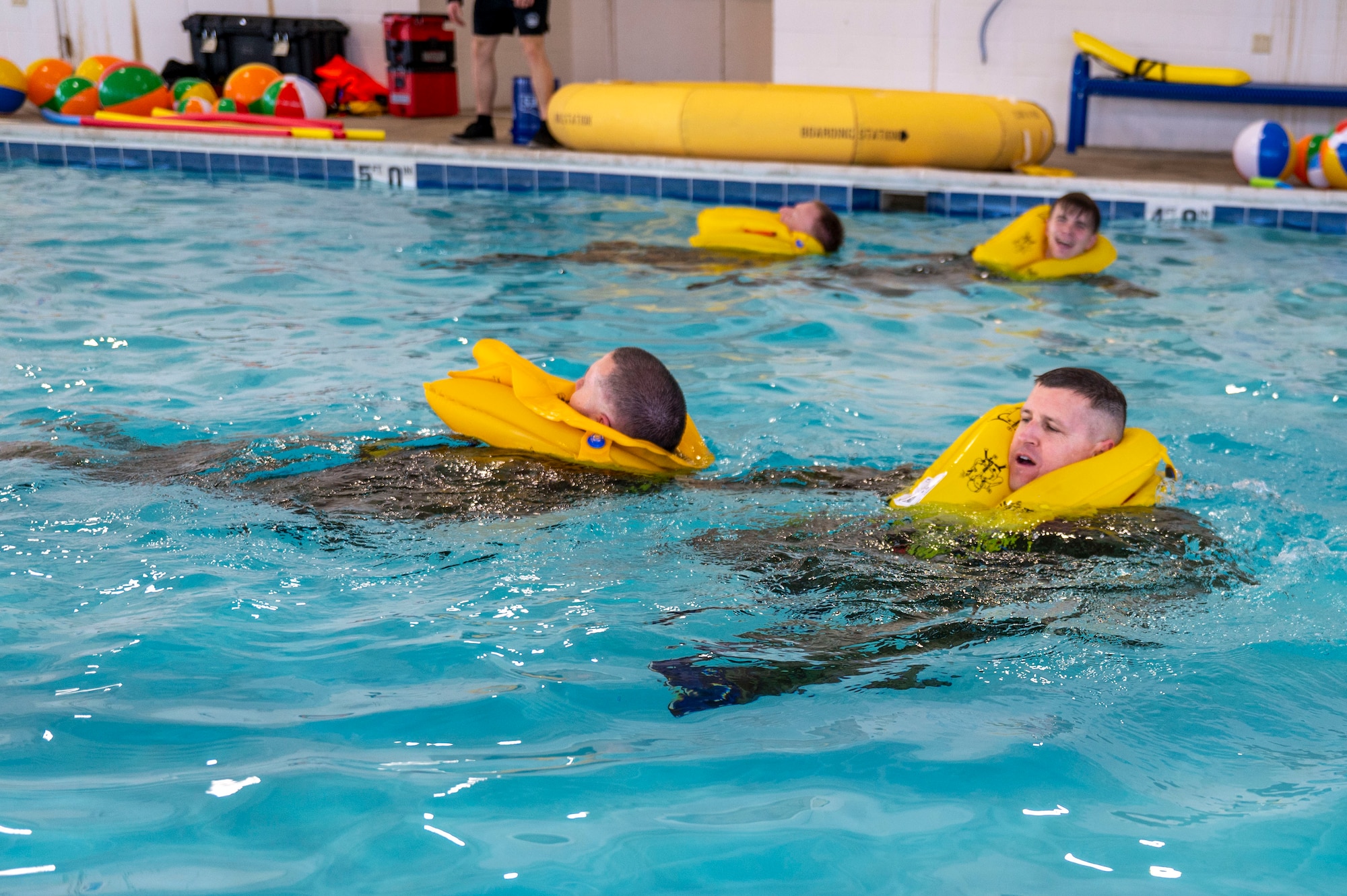 Airmen execute a buddy pull during water survival training taught by a survival, evasion, resistance, escape specialist at Scott Air Force Base on Jan. 16, 2025. Other training provided by the Scott SERE shop includes, land navigation, combatives, weapons familiarization, drownproofing, conduct after capture, local area survival, small unit tactics and vehicle maneuvers. (U.S. Air Force photo by Rachel Sansano)