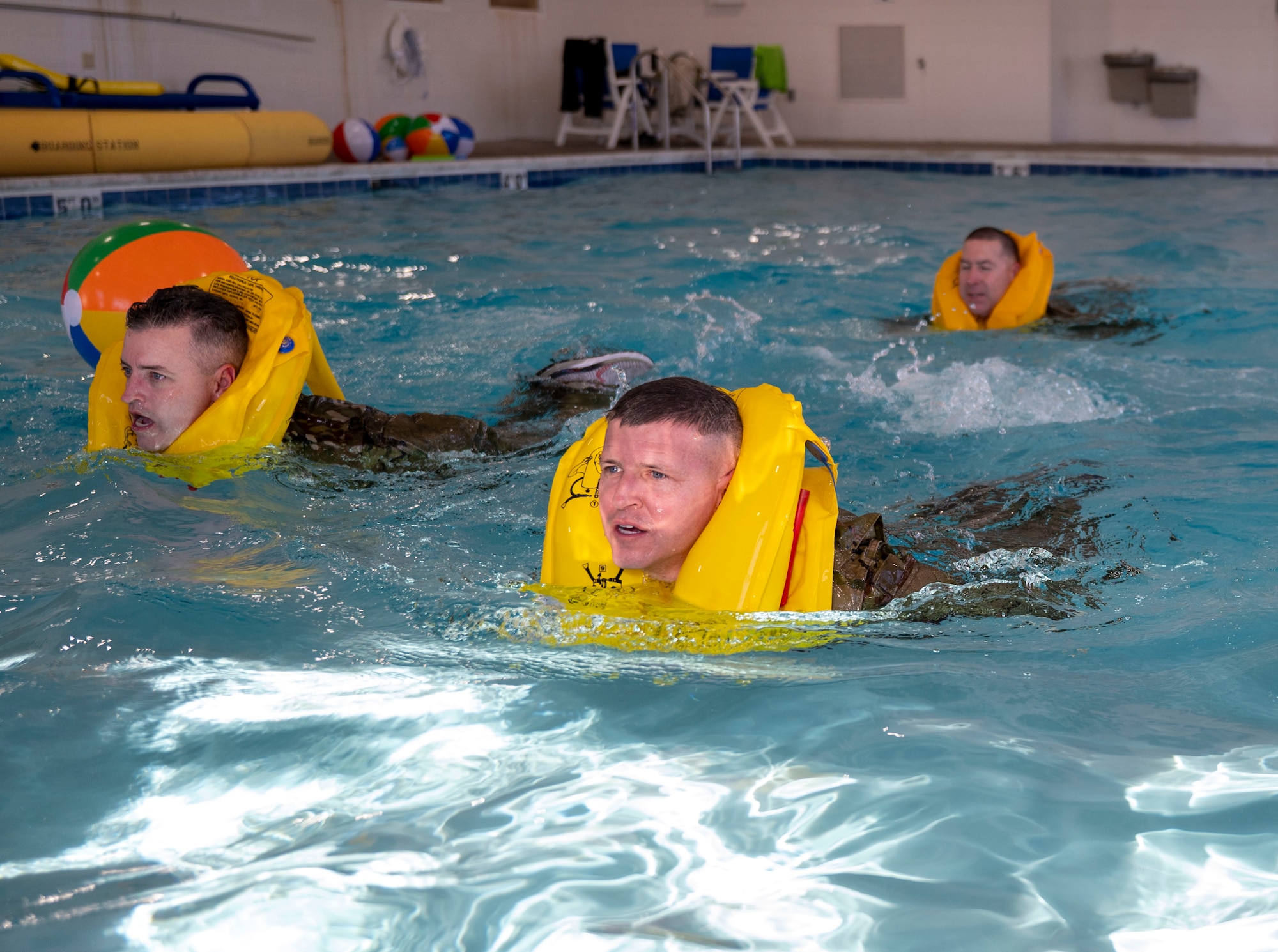 Airmen participate in water survival training at Scott Air Force Base on Jan. 16, 2025. Other training provided by the Scott survival, evasion, resistance, escape shop includes, land navigation, combatives, weapons familiarization, drownproofing, conduct after capture, local area survival, small unit tactics and vehicle maneuvers. (U.S. Air Force photo by Rachel Sansano)