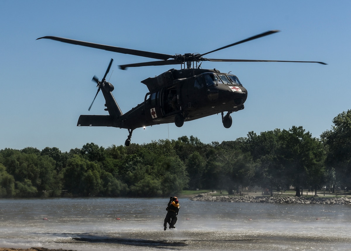 The 6-101st Aviation Regiment from Fort Campbell, Ky. hold their first-ever medical evacuation water extraction with Survive, Evade, Resist, and Escape instructors from Scott Air Force Base at Lake Carlyle, Ill., June 7, 2017. Lt. Col. Brooke Matson, 375th Operations Support Squadron, Lt. Col. Brandon Dow, 54th Airlift Squadron, and Maj. Madison Basil Jr., Headquarters Air Mobility Command, received hoist, water survival, and flare training to learn how to survive in aquatic situations long enough to be rescued. The 101st Combat Aviation Brigade has served in almost every single military operation since the Vietnam War, including combat, peacekeeping, and humanitarian.  By partnering with Air Mobility Command’s SERE instructors, this training allows for joint-service coordination while preparing aerial crew members to survive in austere locations after being displaced from their aircraft.  (U.S. Air Force photo by Staff Sgt. Jodi Martinez)