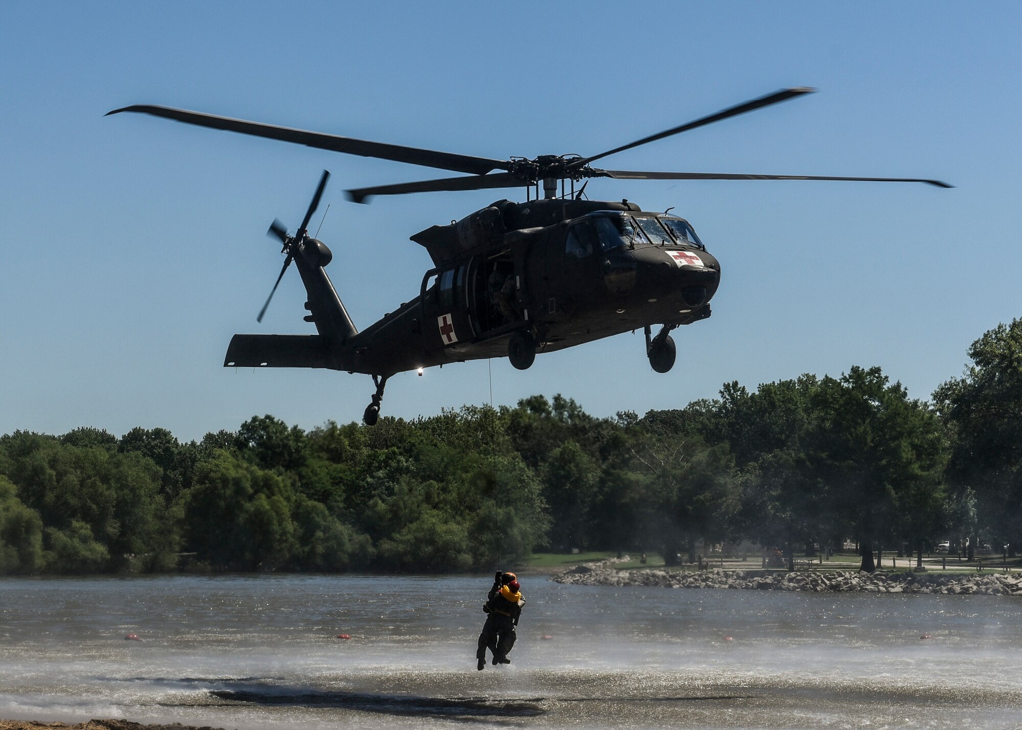 The 6-101st Aviation Regiment from Fort Campbell, Ky. hold their first-ever medical evacuation water extraction with Survive, Evade, Resist, and Escape instructors from Scott Air Force Base at Lake Carlyle, Ill., June 7, 2017. Lt. Col. Brooke Matson, 375th Operations Support Squadron, Lt. Col. Brandon Dow, 54th Airlift Squadron, and Maj. Madison Basil Jr., Headquarters Air Mobility Command, received hoist, water survival, and flare training to learn how to survive in aquatic situations long enough to be rescued. The 101st Combat Aviation Brigade has served in almost every single military operation since the Vietnam War, including combat, peacekeeping, and humanitarian.  By partnering with Air Mobility Command’s SERE instructors, this training allows for joint-service coordination while preparing aerial crew members to survive in austere locations after being displaced from their aircraft.  (U.S. Air Force photo by Staff Sgt. Jodi Martinez)