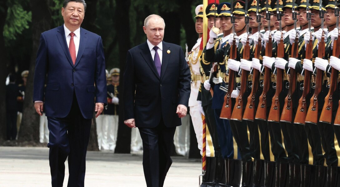 Russian President Vladimir Putin (right) is escorted by Chinese President Xi Jinping during honor guard review at formal arrival ceremony outside
Great Hall of the People.