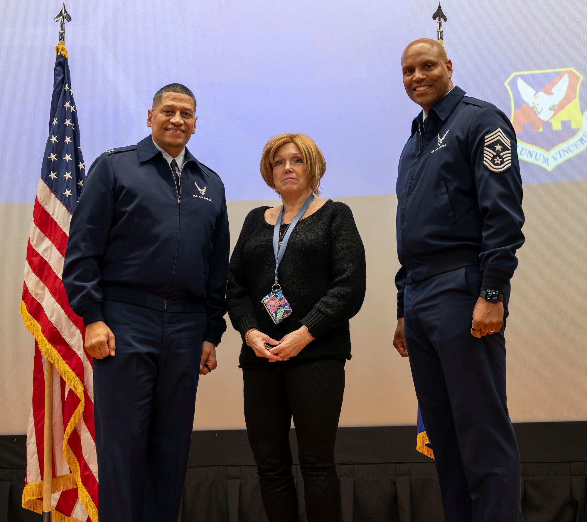 U.S. Air Force Col. Anthony L. Smith, Joint Base McGuire-Dix-Lakehurst and 87th Air Base Wing commander and Chief Master Sgt. Michael Wynne, 87th ABW command chief, recognize Melody Ciulo, 87th Contracting Squadron lead contract specialist, for her 40 years of government service during the 87th ABW civilian all-call at JB MDL, N.J., Jan. 23, 2025. The event provided a venue for civilian employees to receive information from the 87th ABW commander on pertinent topics, to ask questions specific to employee relations and to receive recognition. (U.S. Air Force photo by Susan Moriarty)
