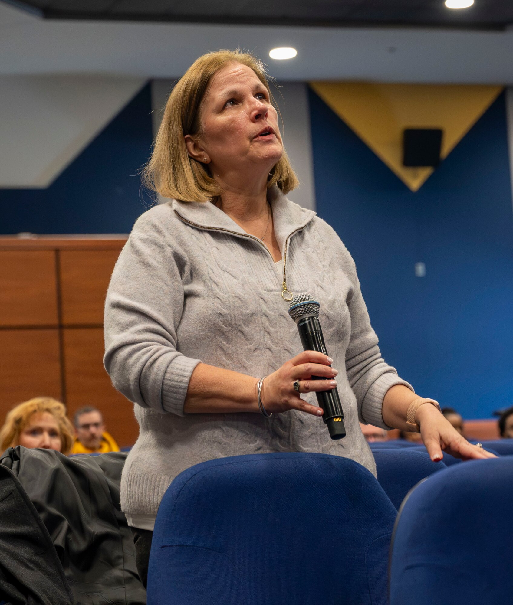 Kimberly Bash, 87th Air Base Wing Judge Advocate Victim Witness Assistance Program coordinator, asks a question during the 87th ABW civilian all-call at Joint Base McGuire-Dix-Lakehurst, N.J., Jan. 23, 2025. The event provided a venue for civilian employees to receive information from the 87th ABW commander on pertinent topics, to ask questions specific to employee relations and to receive recognition. (U.S. Air Force photo by Susan Moriarty)