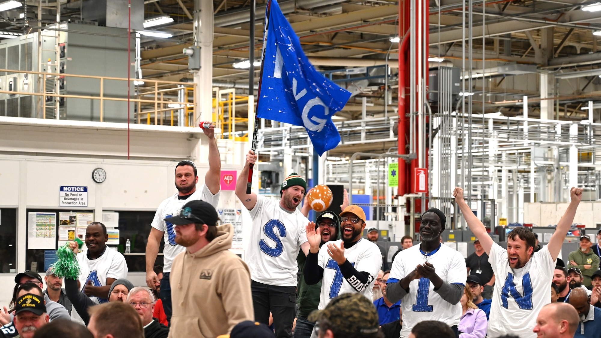 A group cheering with a blue flag