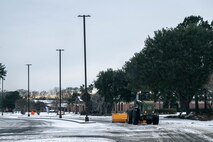An Airman operates heavy machinery to remove snow