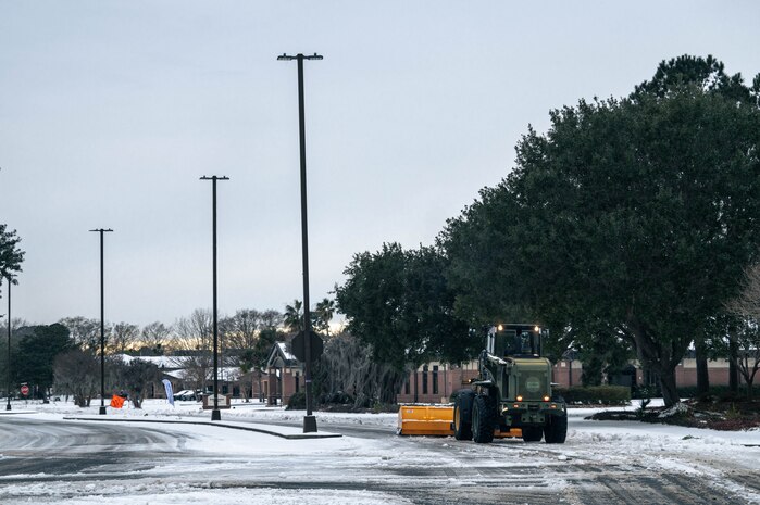 An Airman operates heavy machinery to remove snow