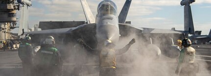 A Sailor directs an E/A-18G Growler from the "Cougars" of Electronic Attack Squadron (VAQ) 139 on the flight deck of the aircraft carrier USS Nimitz (CVN 68) in the Pacific Ocean, Jan. 18, 2025.