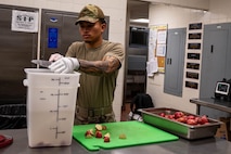 An Airman prepares food