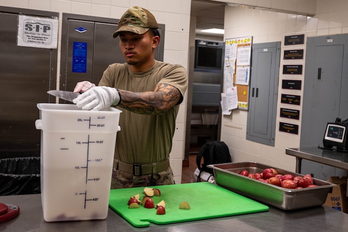 An Airman prepares food