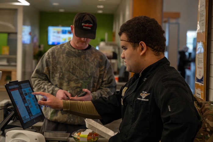 An Airman processes a food order