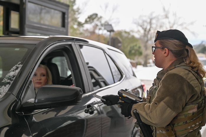 An Airman at the front gate of Joint Base Charleston checking IDs