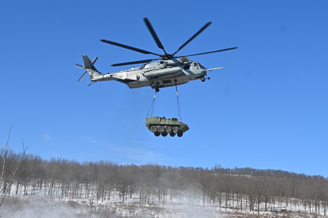 A Marine CH-53 Super Stallion helicopter from Marine Heavy Helicopter Squadron 772 out of Joint Base Maguire-Dix-Lakehurst, New Jersey, air-lifts a decommissioned Army Stryker vehicle to Fort Indiantown Gap’s impact area Jan. 22, 2025. A team of Air Force sling-load specialists from the 621st Contingency Response Group sling-loaded the Stryker to the helicopter. (Pennsylvania National Guard photo by Brad Rhen)