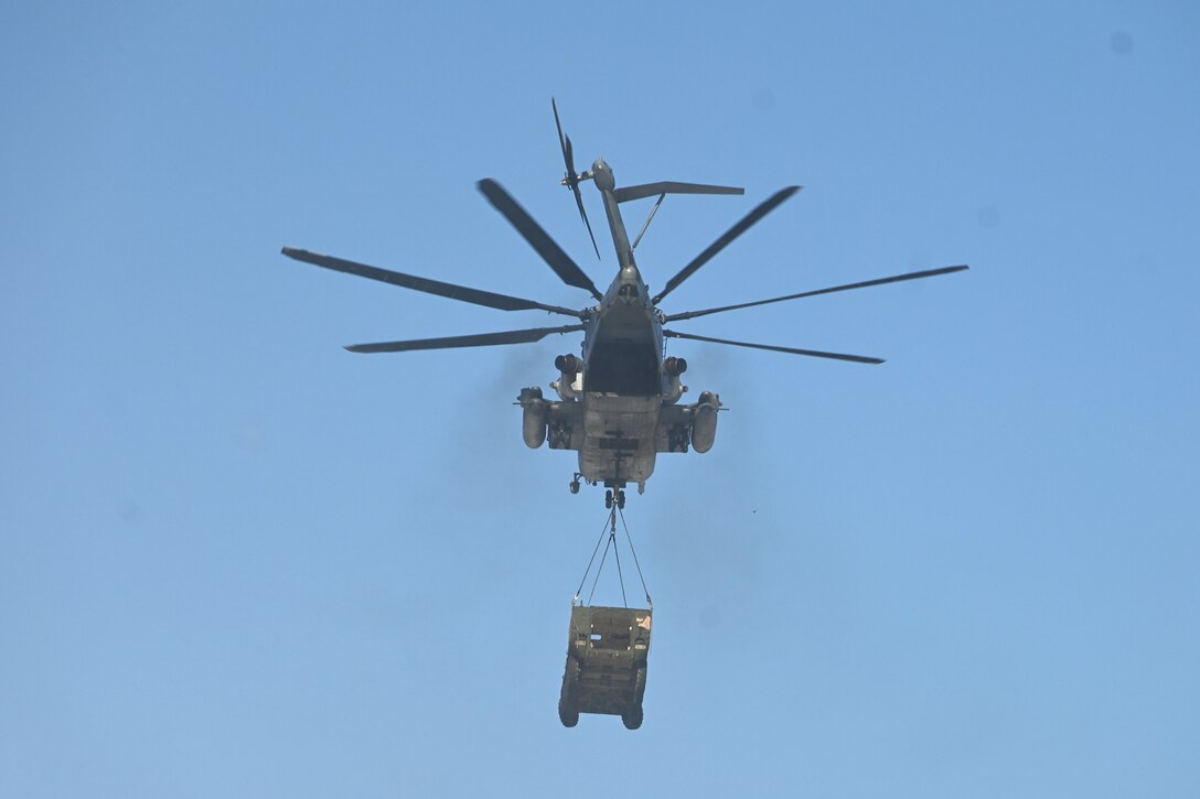 A Marine CH-53 Super Stallion helicopter from Marine Heavy Helicopter Squadron 772 out of Joint Base Maguire-Dix-Lakehurst, New Jersey, air-lifts a decommissioned Army Stryker vehicle to Fort Indiantown Gap’s impact area Jan. 22, 2025. A team of Air Force sling-load specialists from the 621st Contingency Response Group sling-loaded the Stryker to the helicopter. (Pennsylvania National Guard photo by Brad Rhen)