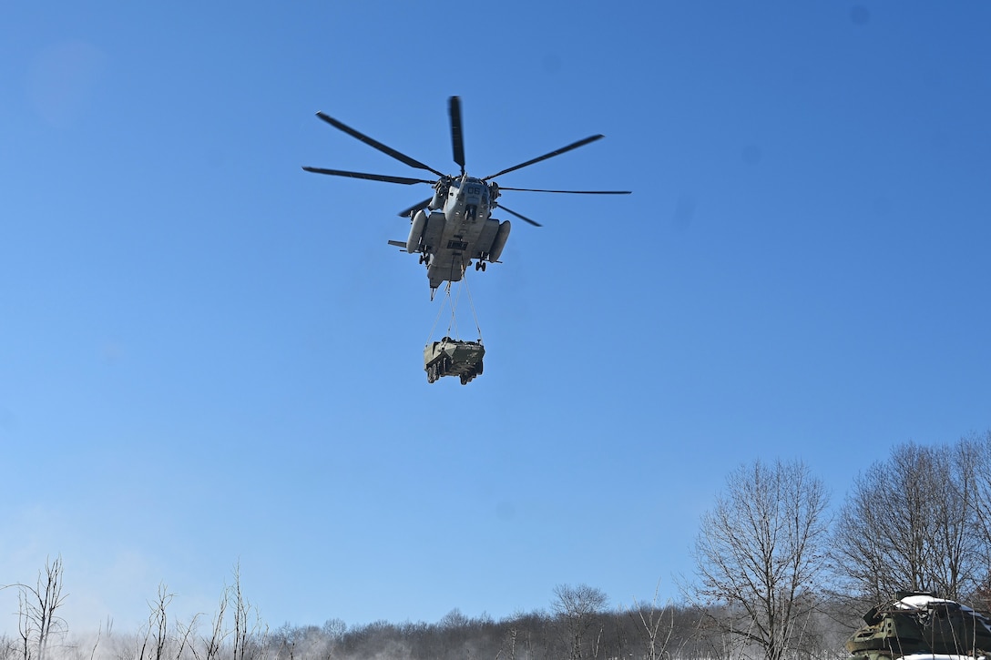 A Marine CH-53 Super Stallion helicopter from Marine Heavy Helicopter Squadron 772 out of Joint Base Maguire-Dix-Lakehurst, New Jersey, air-lifts a decommissioned Army Stryker vehicle to Fort Indiantown Gap’s impact area Jan. 22, 2025. A team of Air Force sling-load specialists from the 621st Contingency Response Group sling-loaded the Stryker to the helicopter. (Pennsylvania National Guard photo by Brad Rhen)