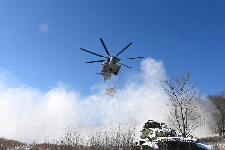 A Marine CH-53 Super Stallion helicopter from Marine Heavy Helicopter Squadron 772 out of Joint Base Maguire-Dix-Lakehurst, New Jersey, air-lifts a decommissioned Army Stryker vehicle to Fort Indiantown Gap’s impact area Jan. 22, 2025. A team of Air Force sling-load specialists from the 621st Contingency Response Group sling-loaded the Stryker to the helicopter. (Pennsylvania National Guard photo by Brad Rhen)