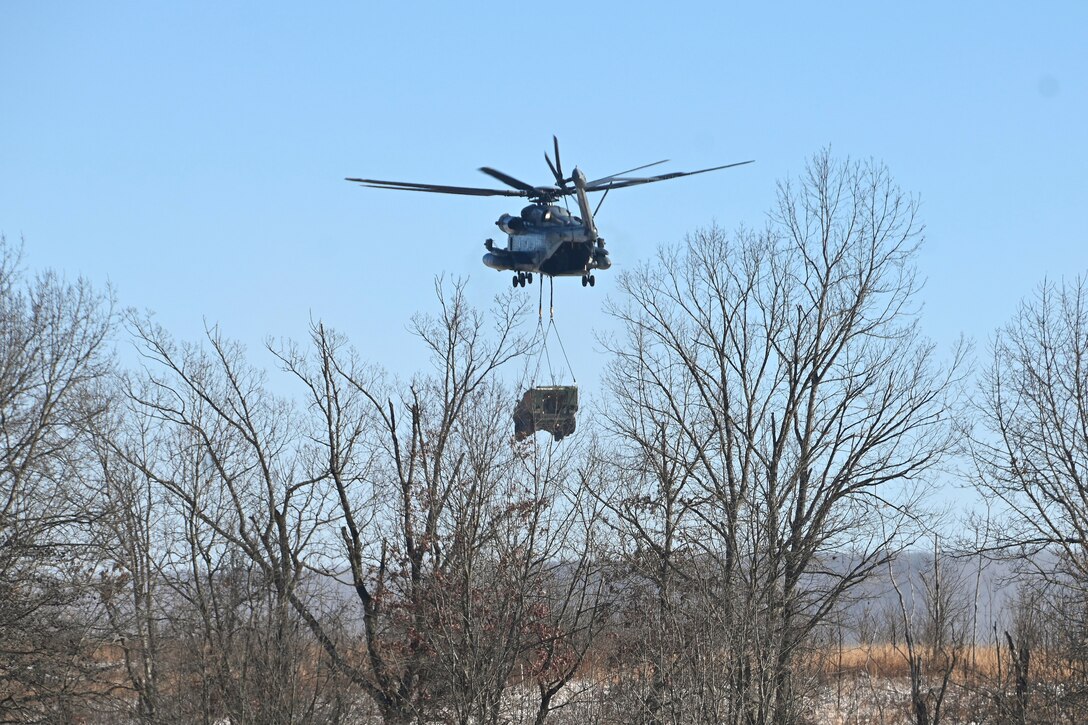 A Marine CH-53 Super Stallion helicopter from Marine Heavy Helicopter Squadron 772 out of Joint Base Maguire-Dix-Lakehurst, New Jersey, air-lifts a decommissioned Army Stryker vehicle to Fort Indiantown Gap’s impact area Jan. 22, 2025. A team of Air Force sling-load specialists from the 621st Contingency Response Group sling-loaded the Stryker to the helicopter. (Pennsylvania National Guard photo by Brad Rhen)